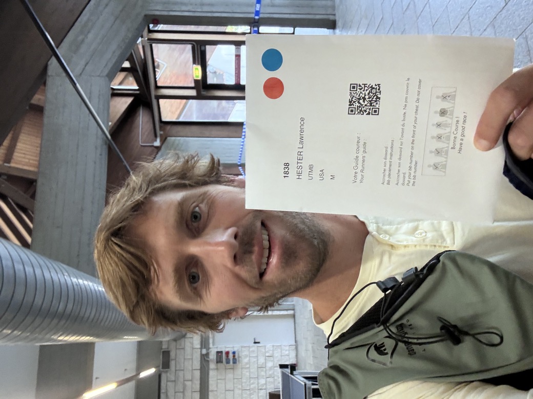 Holding the UTMB runner guide with bib number 1838